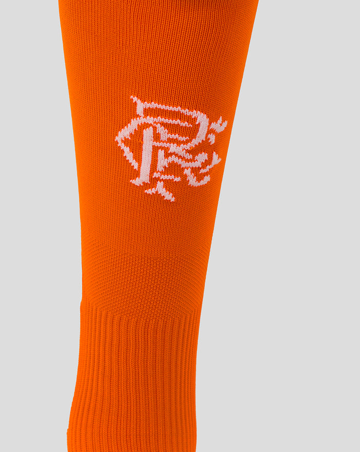 Close-up of bright orange goalkeeper sock showing a white crest graphic on the calf