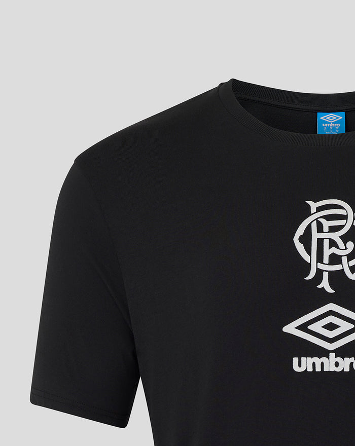Close-up of black unisex travel T-shirt shows white club crest and Umbro logo on the chest