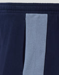 Close-up of navy shorts leg displaying blue club crest and Umbro diamond logo.