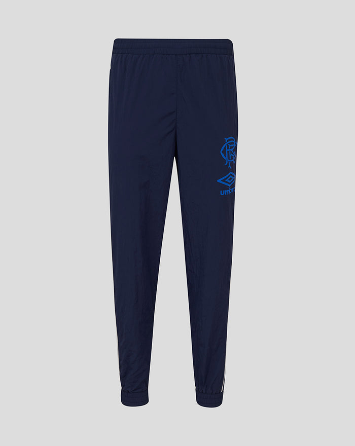Back view of junior navy travel pant with crest on the thigh and white side piping