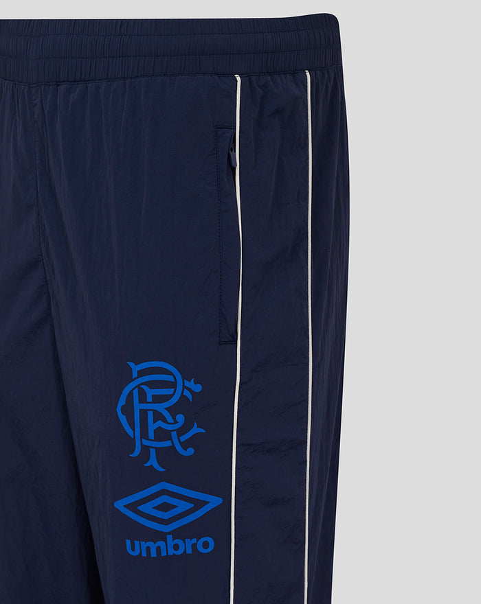 Junior travel pant in navy peacoat with white side piping and blue club crest and Umbro logo on the leg