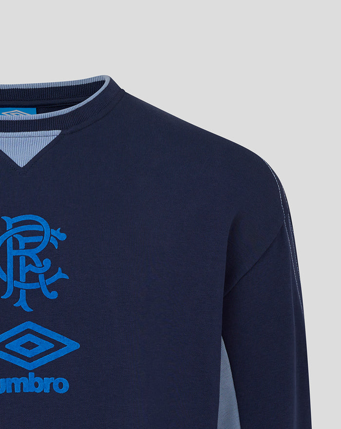 Close-up of the shoulder on navy travel crew sweatshirt with light blue side panel and contrast stitching.
