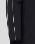 Close-up of a black travel jacket sleeve showing a white piping stripe and the elastic cuff.