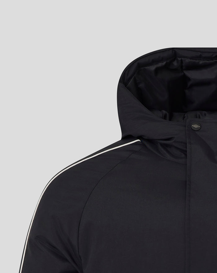 Shoulder and hood area of black travel jacket with white piping along the shoulder seam.