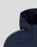 Detail of navy travel bench jacket showing hood and shoulder with white piping