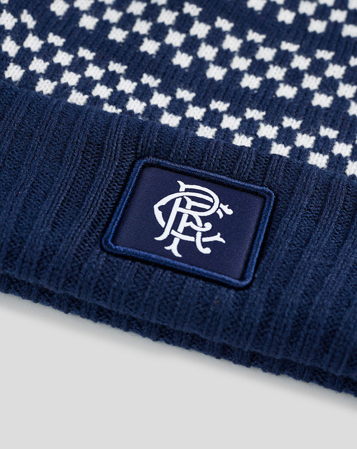 Close up of navy Rangers knitted bobble hat with white pattern and a stitched patch