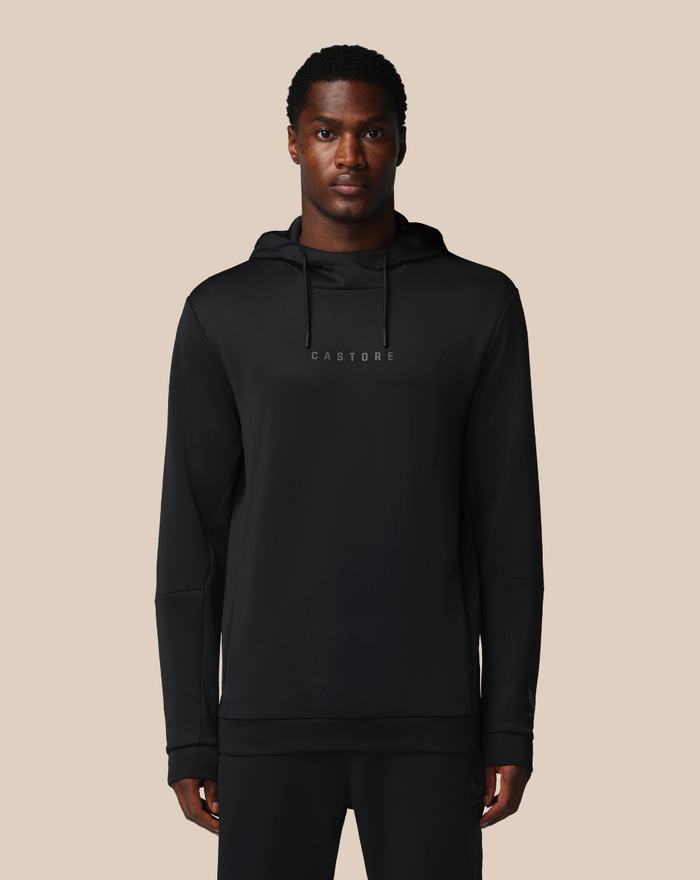 Front view of a man in a black flex hoodie with a small chest logo