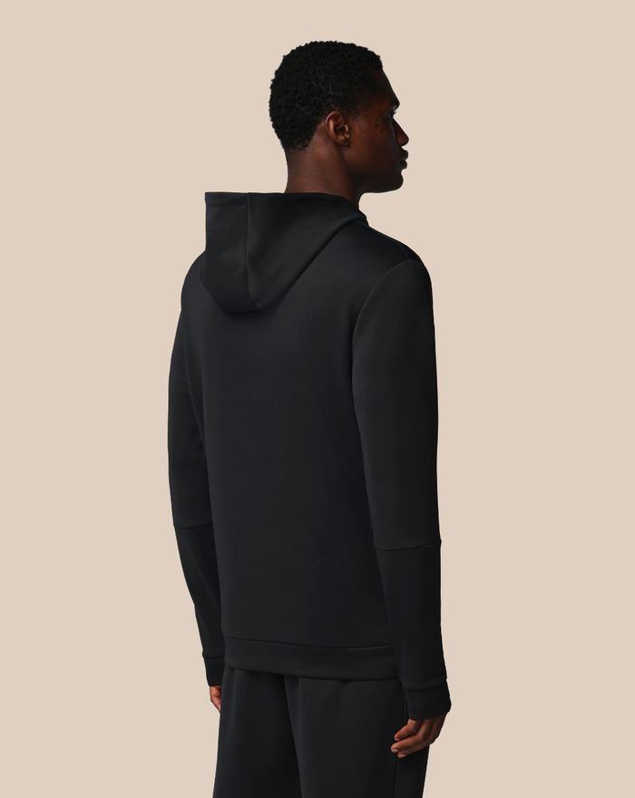 Back three-quarter view of a man in a black hooded sweatshirt with the hood down
