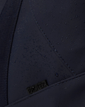 Close-up of navy CORE HOLDALL exterior with water droplets on rainproof fabric