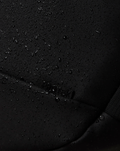 Close up of black water resistant fabric with droplets beading on the surface and PROTEK label