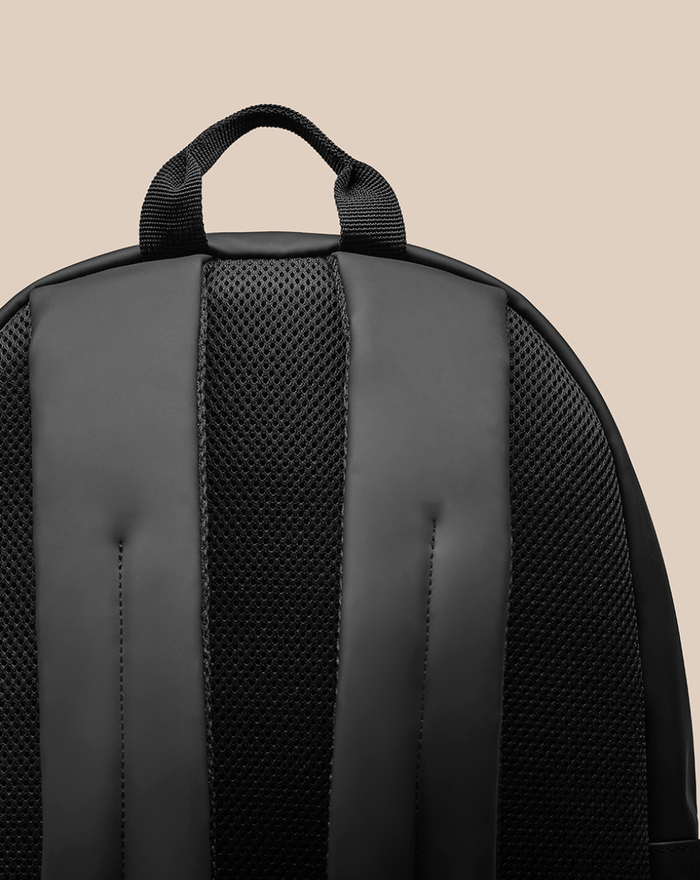 Back of CORE BACKPACK with padded shoulder straps and breathable mesh panel.