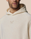 Beige cotton fleece hoodie with a small wing logo on the chest worn by a model.