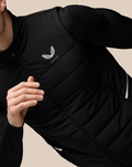 Close up of black Castore gilet with diagonal zipper and quilted panels