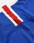 Close-up of blue jersey fabric with white and red cuff trim detail
