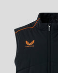Close-up of a black padded gilet with orange piping along the shoulder and an orange Castore logo on the chest.