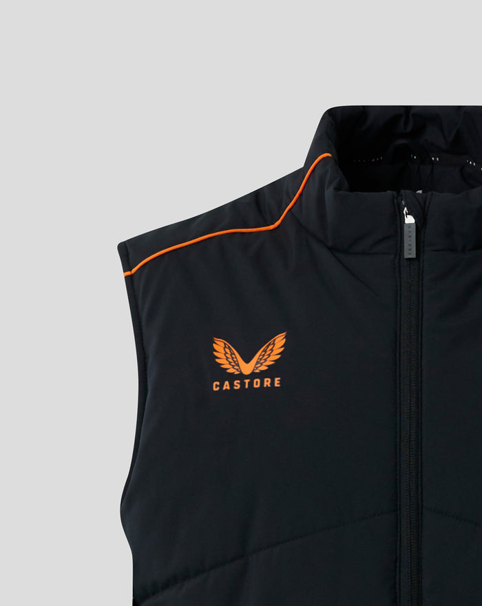 Close-up of a black padded gilet with orange piping along the shoulder and an orange Castore logo on the chest.